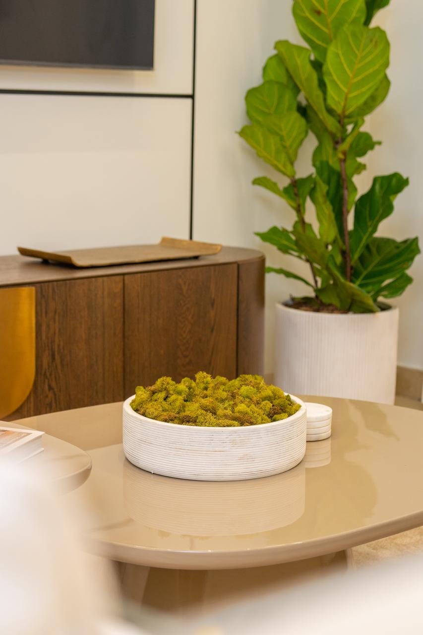 Sala de estar con mesa de centro redonda y sofás por A. Guzman Studio
