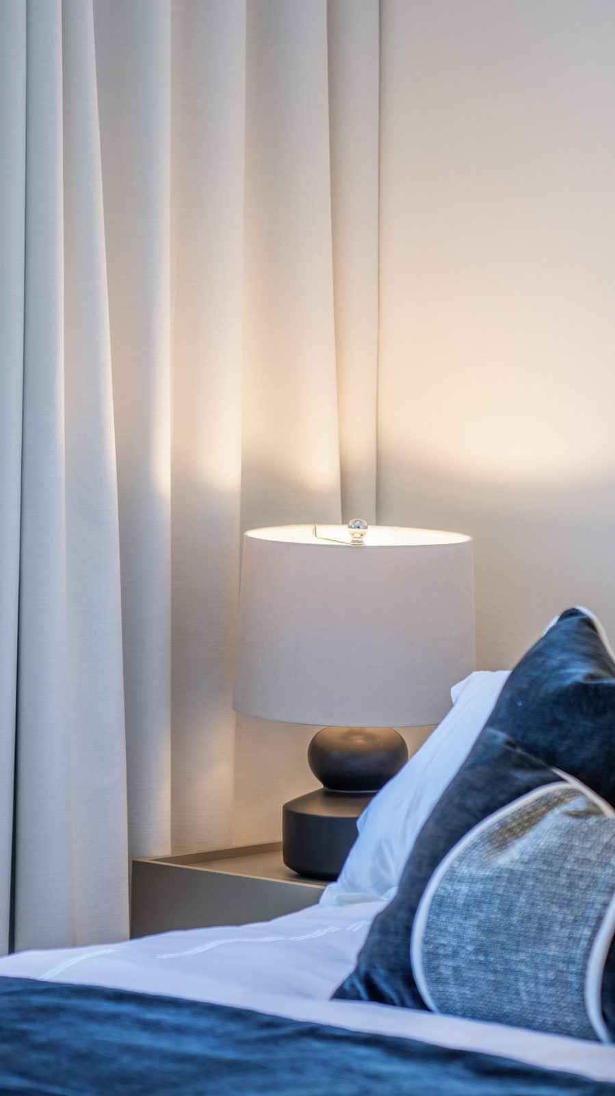 Dormitorio con acentos en azul y lámpara de noche por A. Guzman Studio