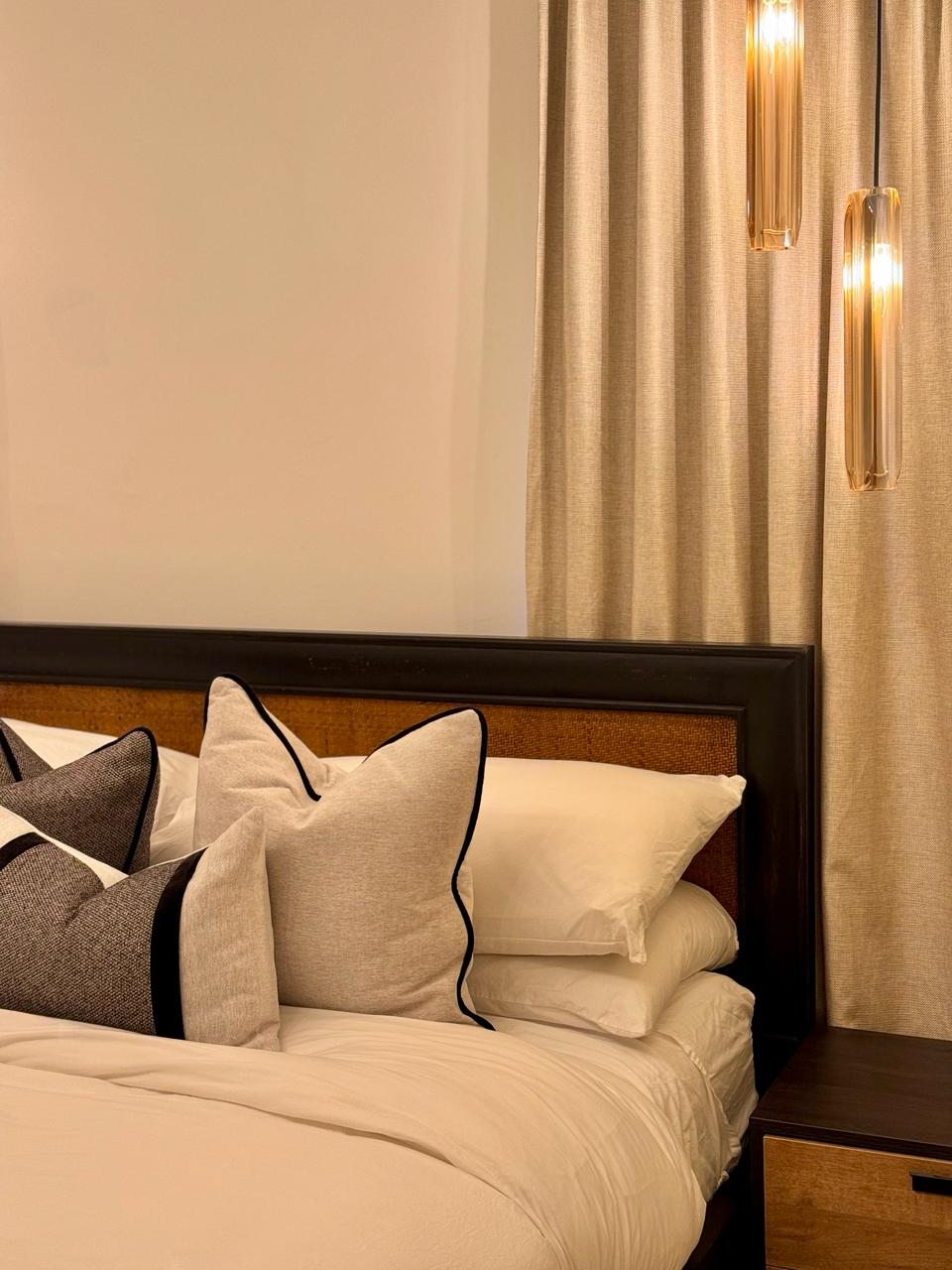 Dormitorio con cabecero tapizado y cojines por A. Guzman Studio