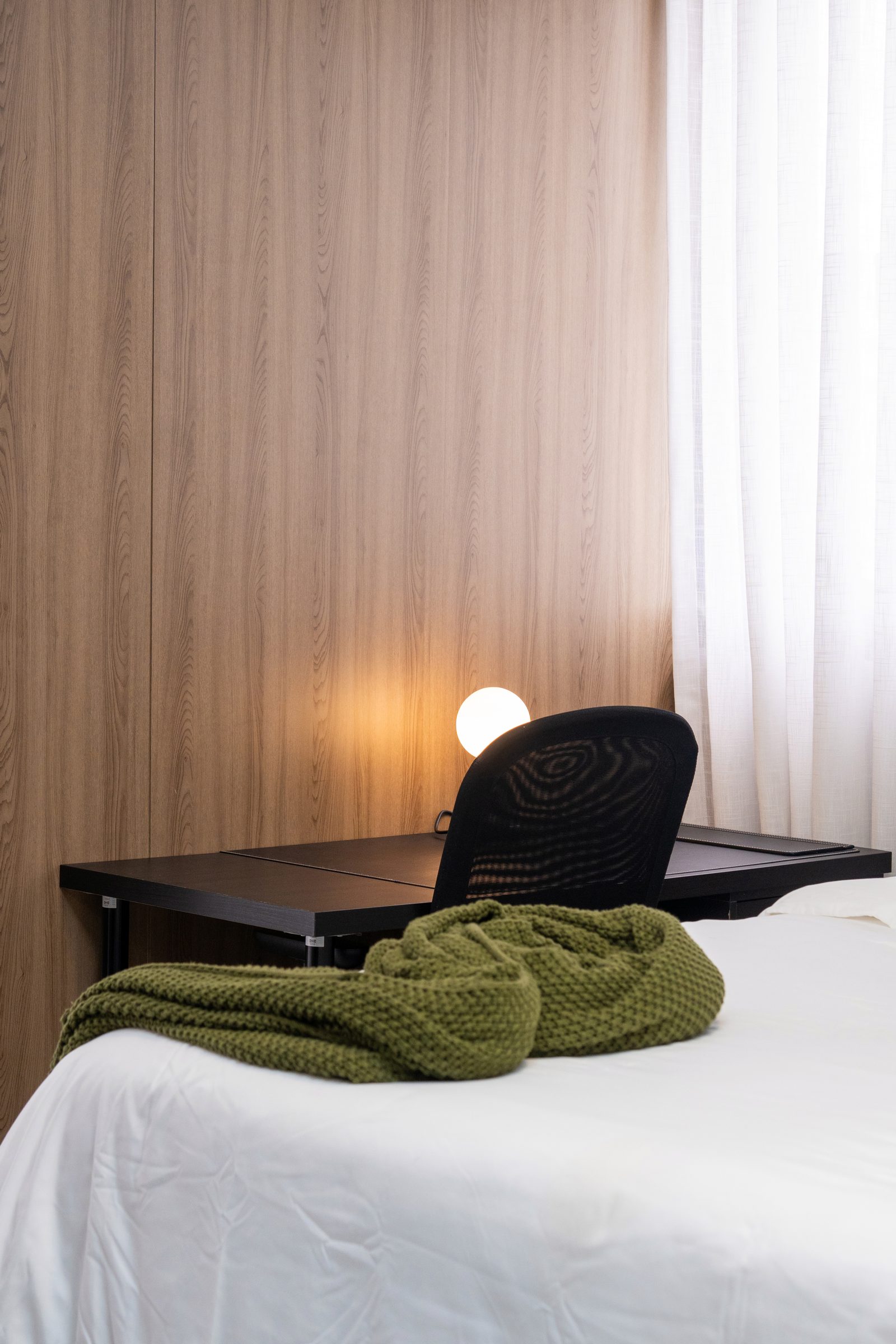 Dormitorio con iluminación cálida en Santo Domingo por A. Guzman Studio