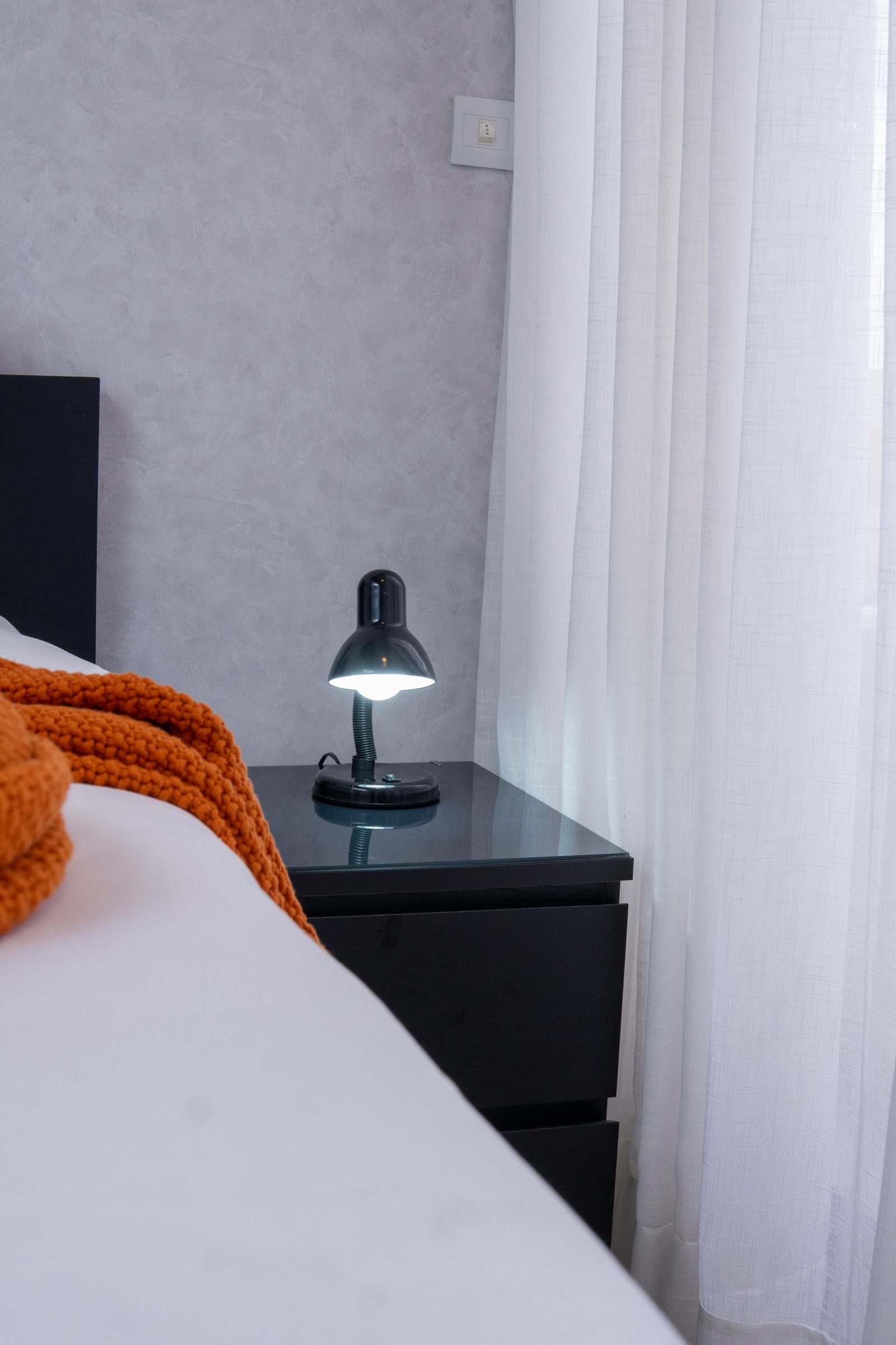 Dormitorio con cabecera oscura en Santo Domingo por A. Guzman Studio